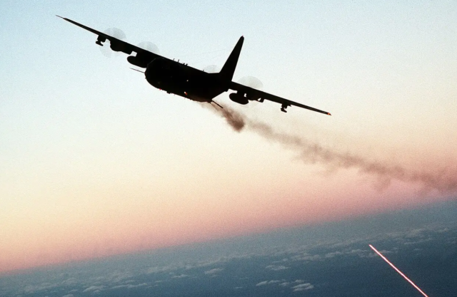An AC-130 gunship lights up the night sky during a live-fire training exercise. The aircraft's side-firing weapons are its defining feature. (U.S. Air Force)