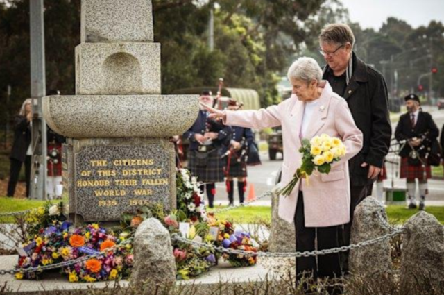 Never forgotten: Lynne Moore, with her son Craig Moore, lays roses inmemory of her husband, Ray Moore, at Croydon war memorial