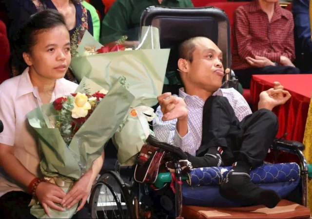 Ms. Do Thi Hang (left) at a program honoring Agent Orange victims who have shown resilience in overcoming adversity. Photo: Hieu Nguyen.